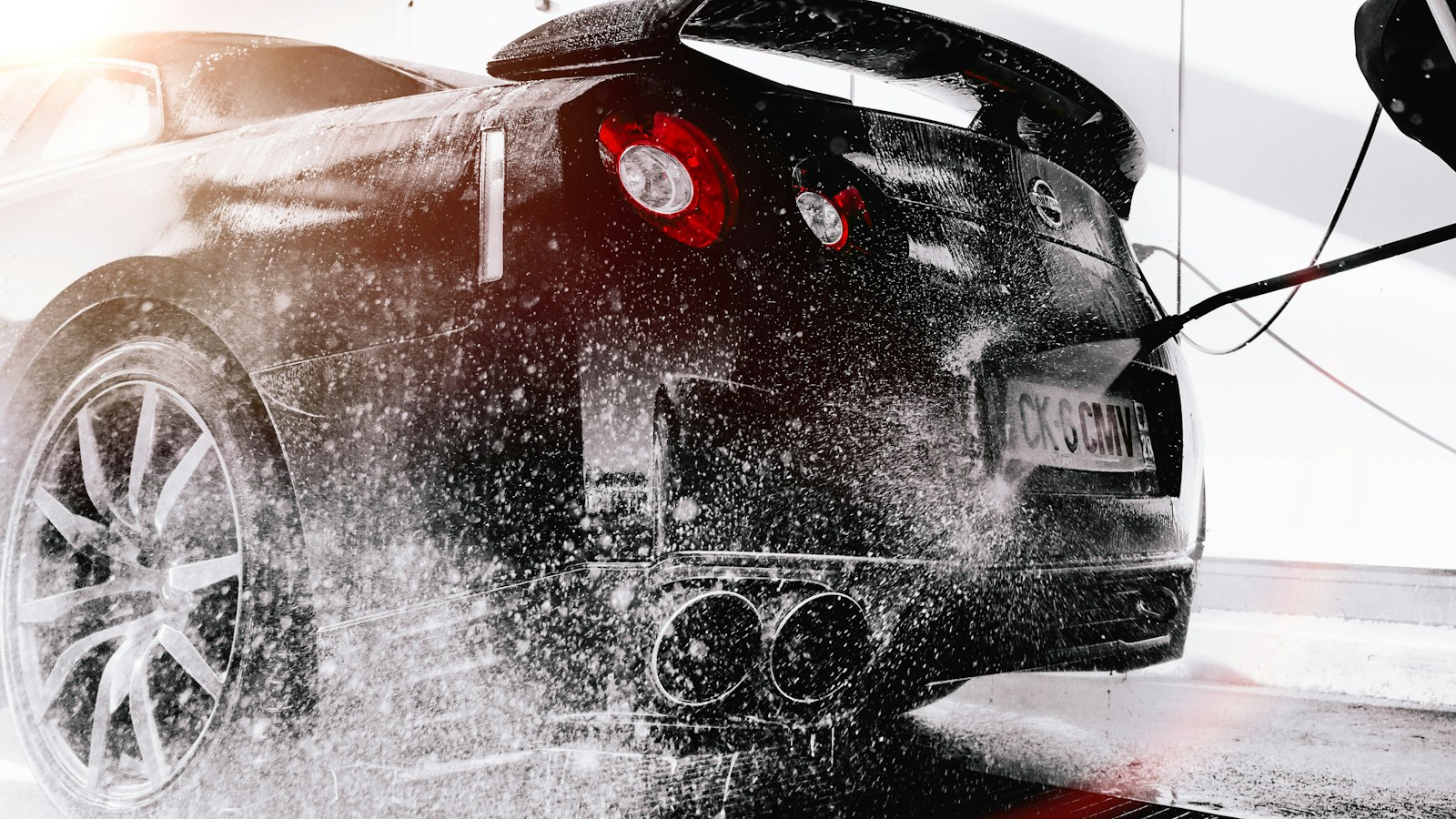 Sports car being carefully washed with a pressure washer